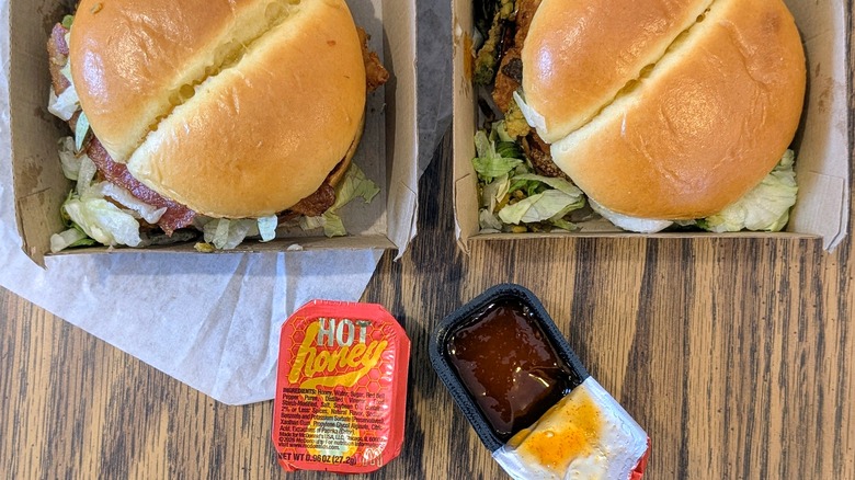 Two McCrispys in boxes and two cups of Hot Honey Sauce
