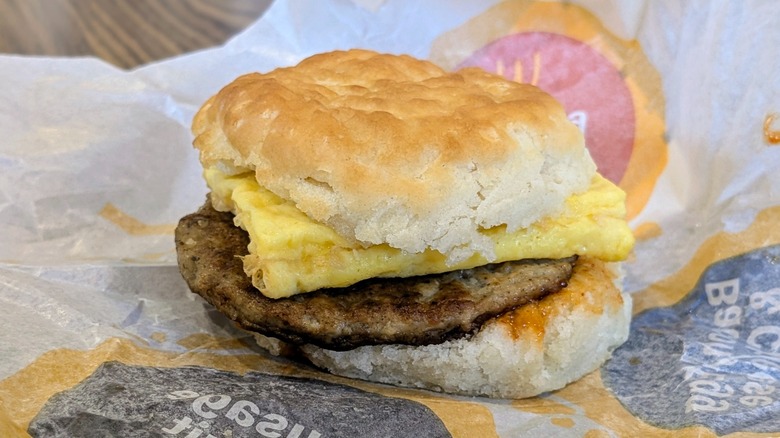 A Sausage Egg Biscuit with hot honey on paper