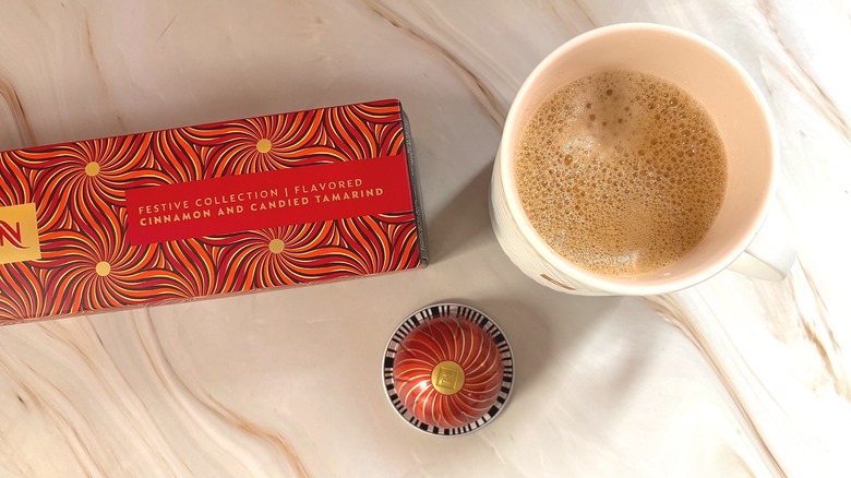 Nespresso Festive Coffee Pack Cinnamon and Candied Tamarind box, capsule, and mug of brewed coffee