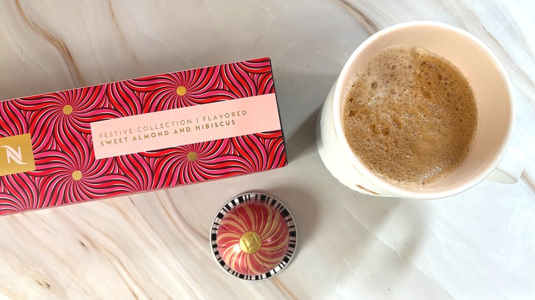 Nespresso Festive Coffee Pack Sweet Almond and Hibiscus box, capsule, and mug of brewed coffee