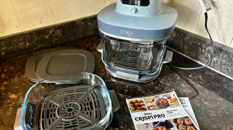 Ninja CRISPi Pro air fryer with an extra basket, lids, and instruction booklet