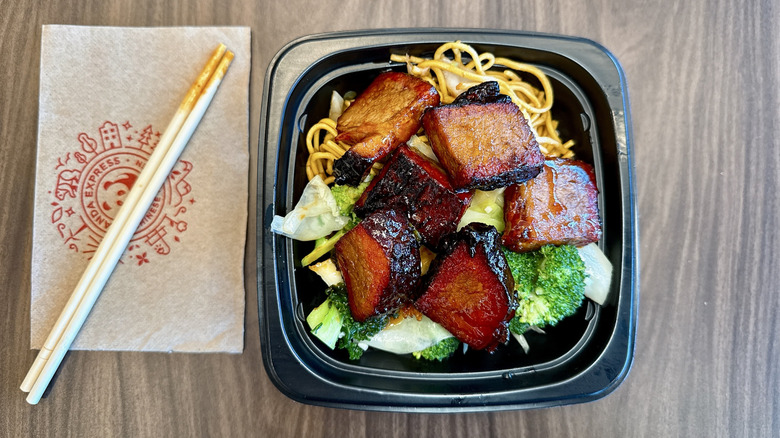 Panda Express Cantonese BBQ Brisket in a to-go bowl with chopsticks on the side