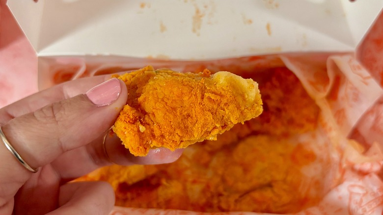 Close-up of Popeyes Buffalo Dry Rub boneless wing over box