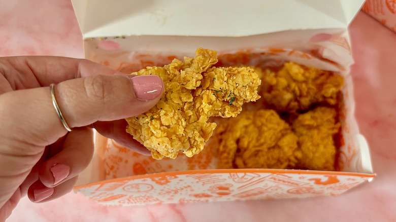 Close-up of Popeyes Garlic Parm Dry Rub boneless wing over box