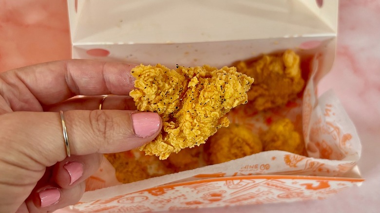 Close-up of Popeyes Lemon Pepper Dry Rub boneless wing over box