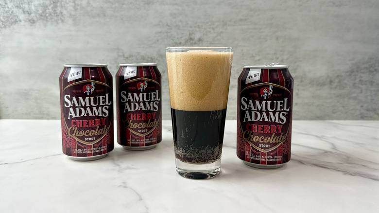 3 cans of Sam Adams cherry chocolate stout and glass of beer