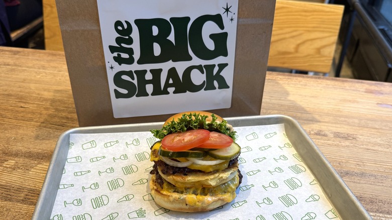 Shake Shack's Big Shack burger on a tray with a special bag in the background