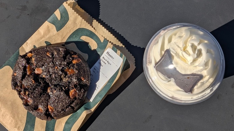 A top view of the Venti Black Night Cookie and Black Cat Frappuccino on a black table