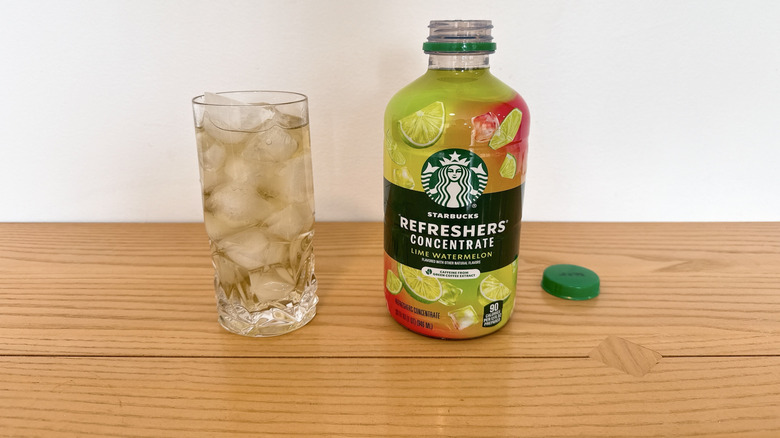 Starbucks Lime Watermelon Refreshers Concentrate bottle and poured into a glass