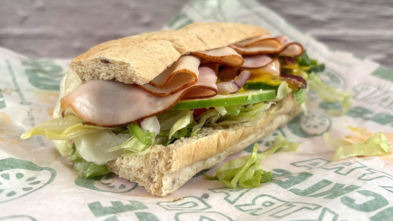 Side view of Subway Ham & Turkey Stacker sandwich on wrapper