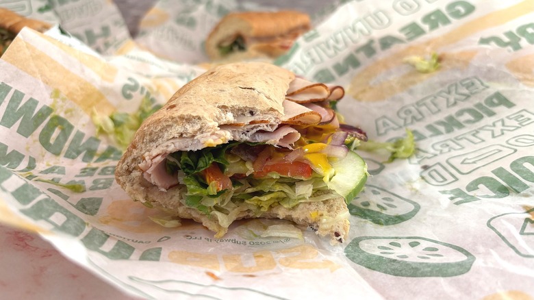 Subway sandwich on wrapper with bite taken out of it