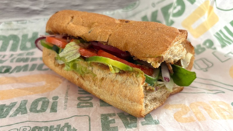 Side view of Subway Seasoned Steak & Avocado sandwich on wrapper