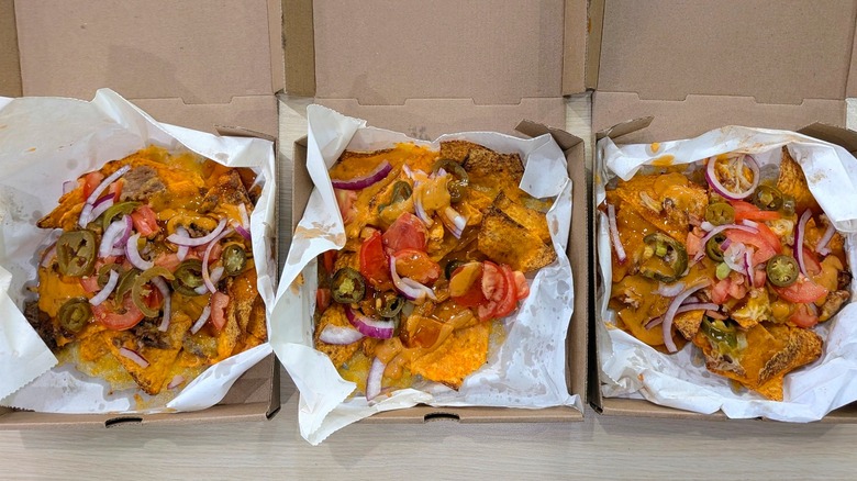 Three cardboard boxes of Doritos Hot Honey Nachos lined with wax paper