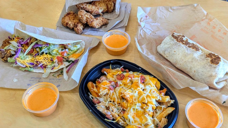 Four Taco Bell items with cups of Frank's RedHot Diablo sauce