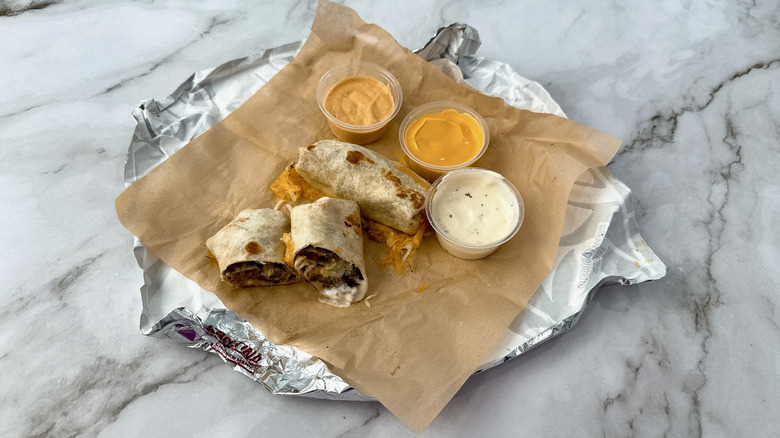 Taco Bell Steak Cheesy Dipping Burritos with three sauces