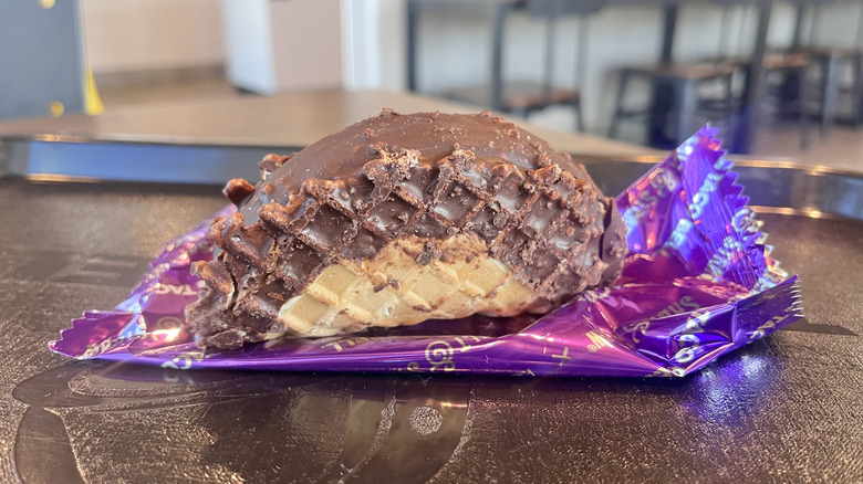 Broken ice cream taco on a wrapper on a tray