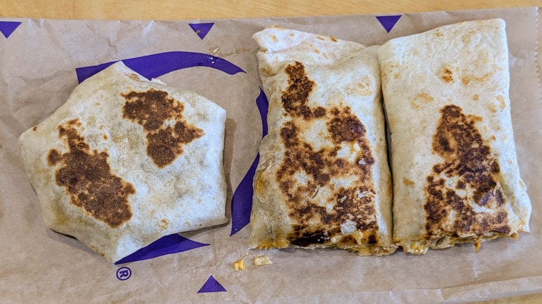 A Crunchwrap and a rolled quesadilla on Taco Bell paper