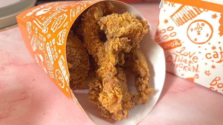 Popeyes chicken dippers in container on pink table