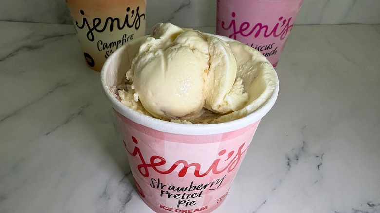 Open pint of Jeni's Strawberry Pretzel Pie ice cream, two other open pints in background