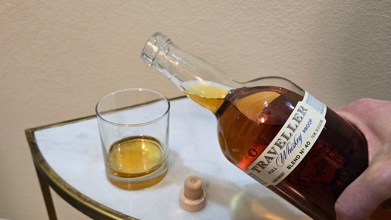 Pouring Traveller Full Proof Whiskey into a rocks glass