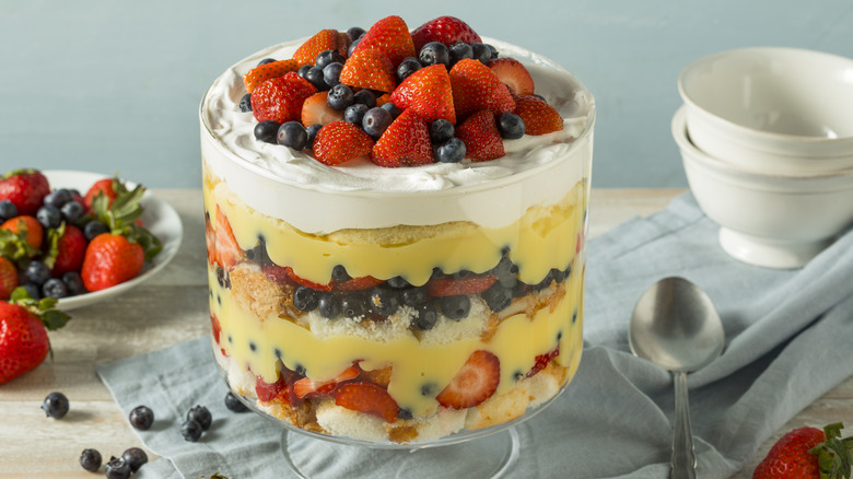 trifle in a classic glass trifle dish with fresh berries and vanilla custard