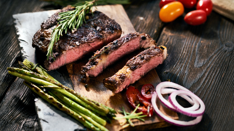 seared and sliced ribeye steak with grilled vegetables