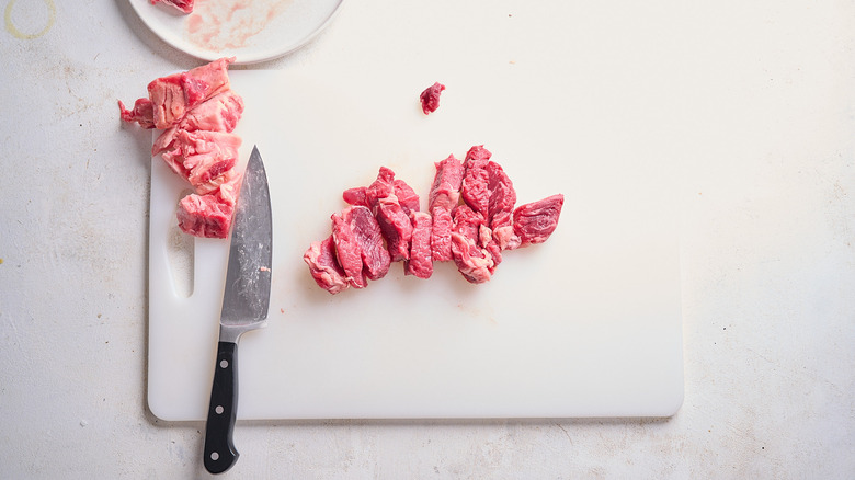 slicing ribeye on a cutting board
