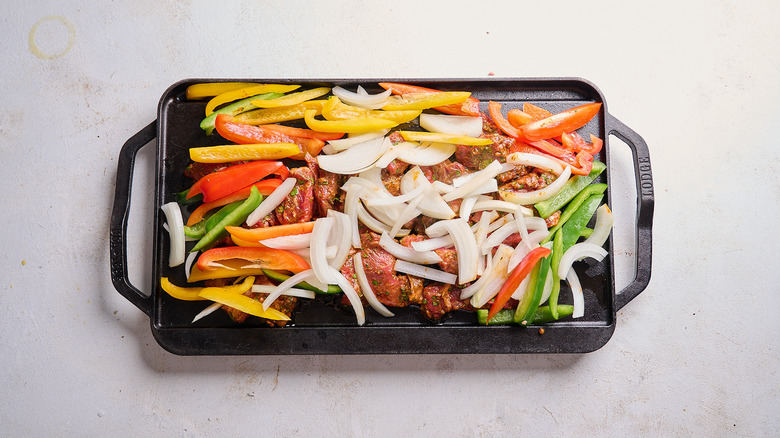 steak and vegetables cooking on a cast iron