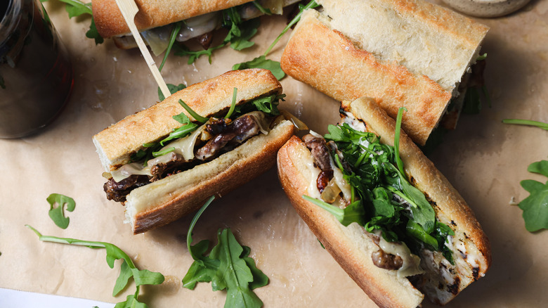 Four ribeye steak sandwiches on parchment