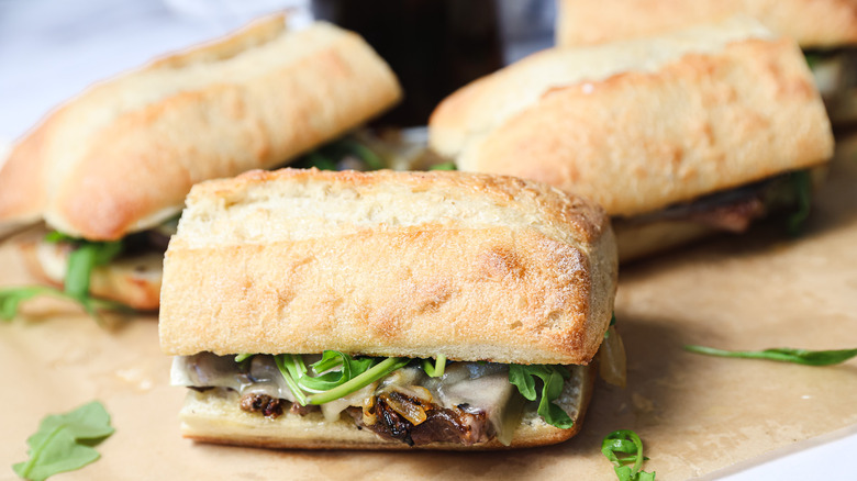 Four ribeye steak sandwiches on parchment