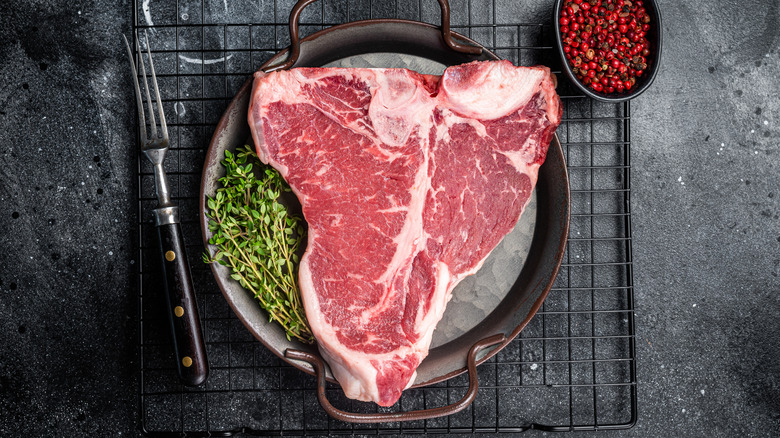 T-bone steak on grill grate.