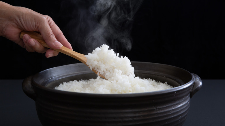 Hand removing rice from rice cooker