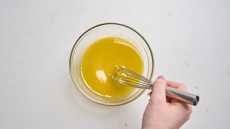 whisking dressing together in a bowl