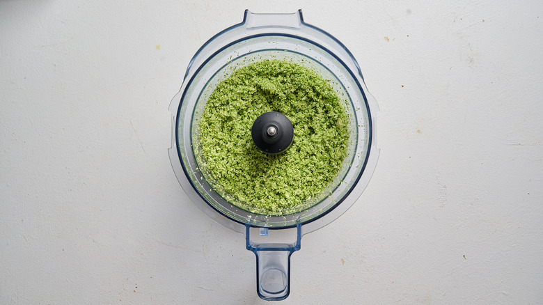 food processor filled with chopped broccoli