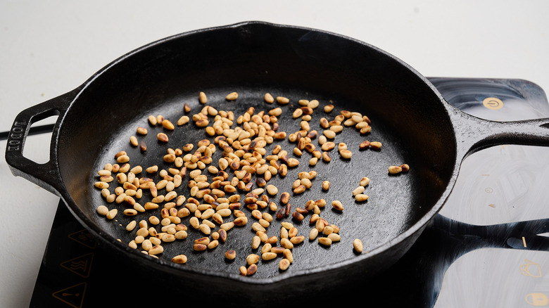 toasting pine nuts in a skillet