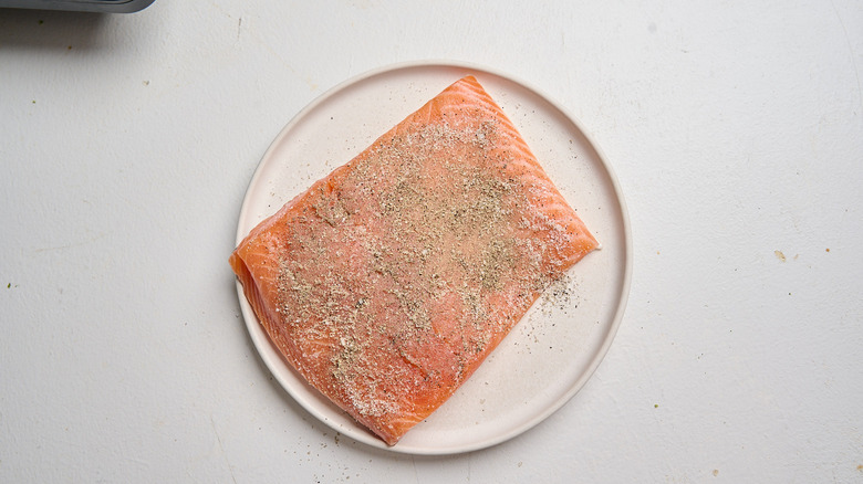 seasoning salmon on a plate