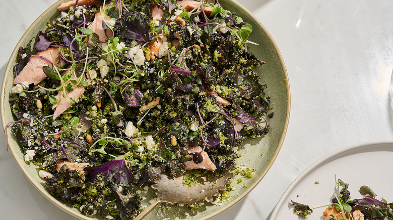 Broccoli and salmon salad in a large serving bowl with a spoon