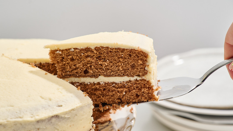 lifting slice of chocolate cake out of cake stand