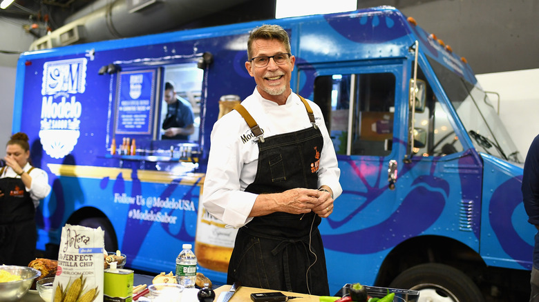 Chef Rick Bayless posing outside a food truck during a cooking demonstration