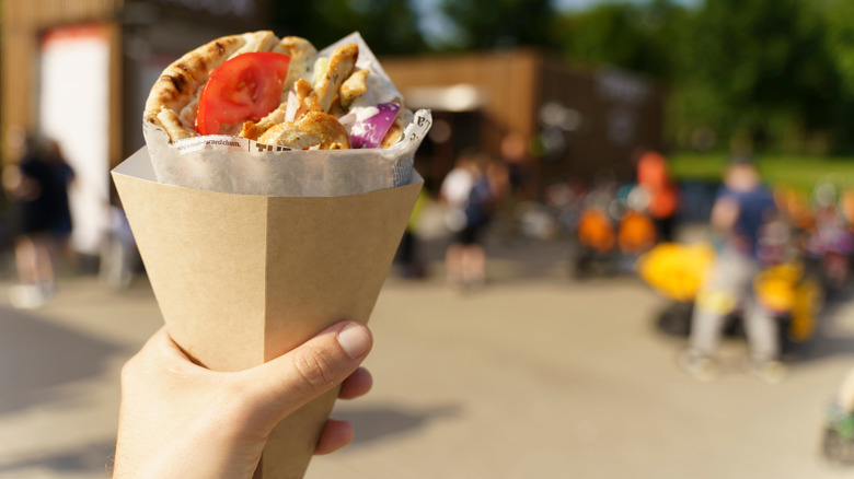 Person holding Greek street food gyros