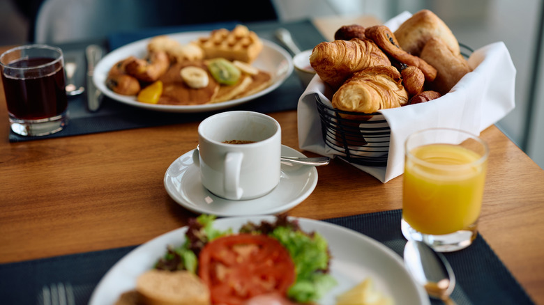 Close up of cup of coffee and breakfast on table in hotel restaurant.