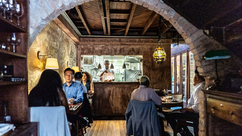Interior of small restaurant with couples dining