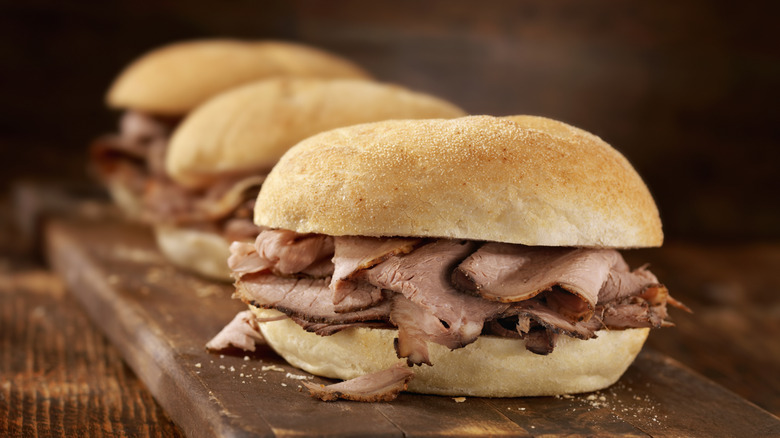roast beef sandwiches on a wooden cutting board