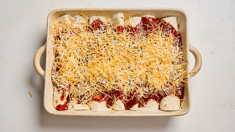 coating enchiladas with sauce and cheese