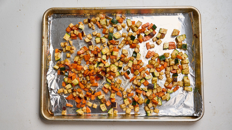 arranging vegetables on a sheet tray