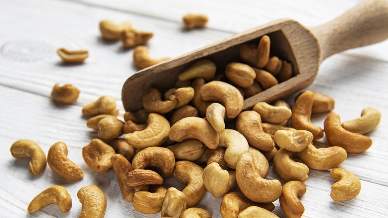Cashew nuts in wooden scoop 