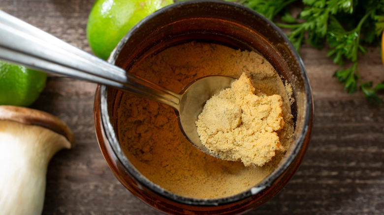 Chicken bouillon powder being scooped out of a jar