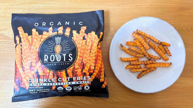 Roots Crinkle Cut Sweet Potato Fries bag next to fries on white plate