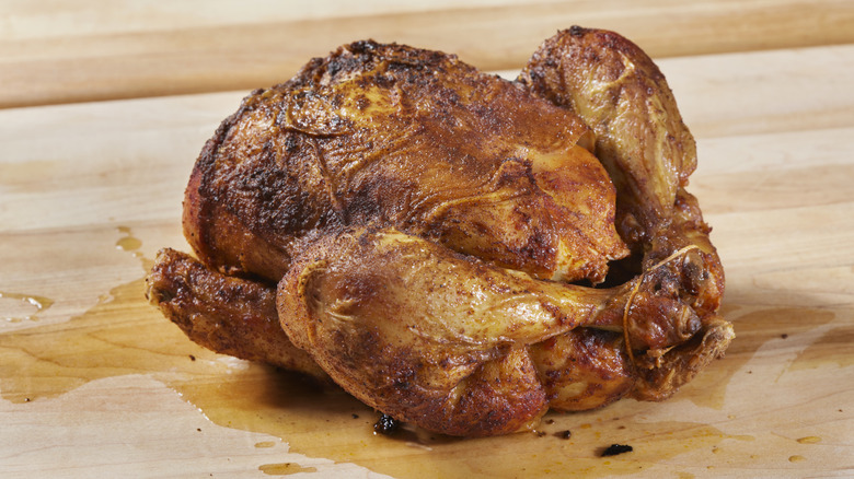 A rotisserie chicken on a cutting board