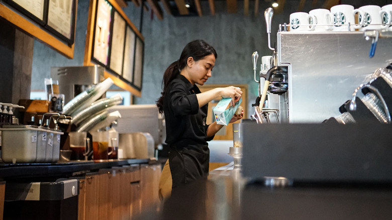 Starbucks employee pouring coffee